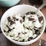 A bowl of scoops of mint ice cream with Oreo pieces.