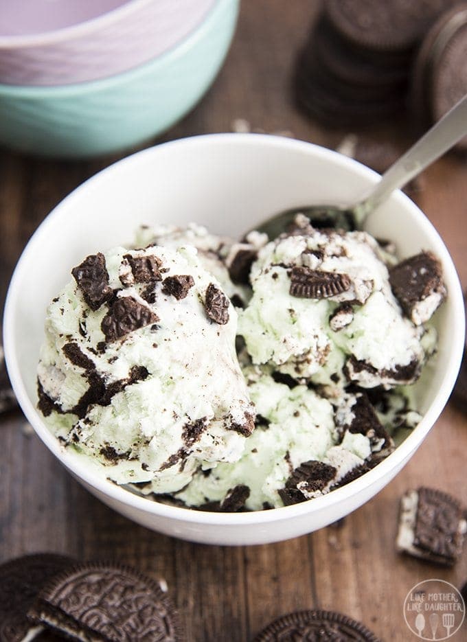 A bowl of scoops of mint ice cream with Oreo pieces. 