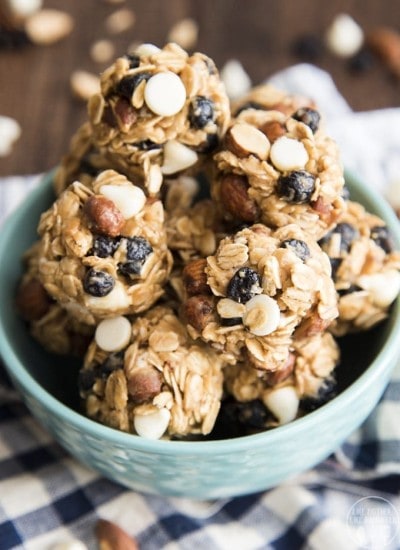 A bowl of granola energy balls full of white chocolate chips, blueberries, and almonds.