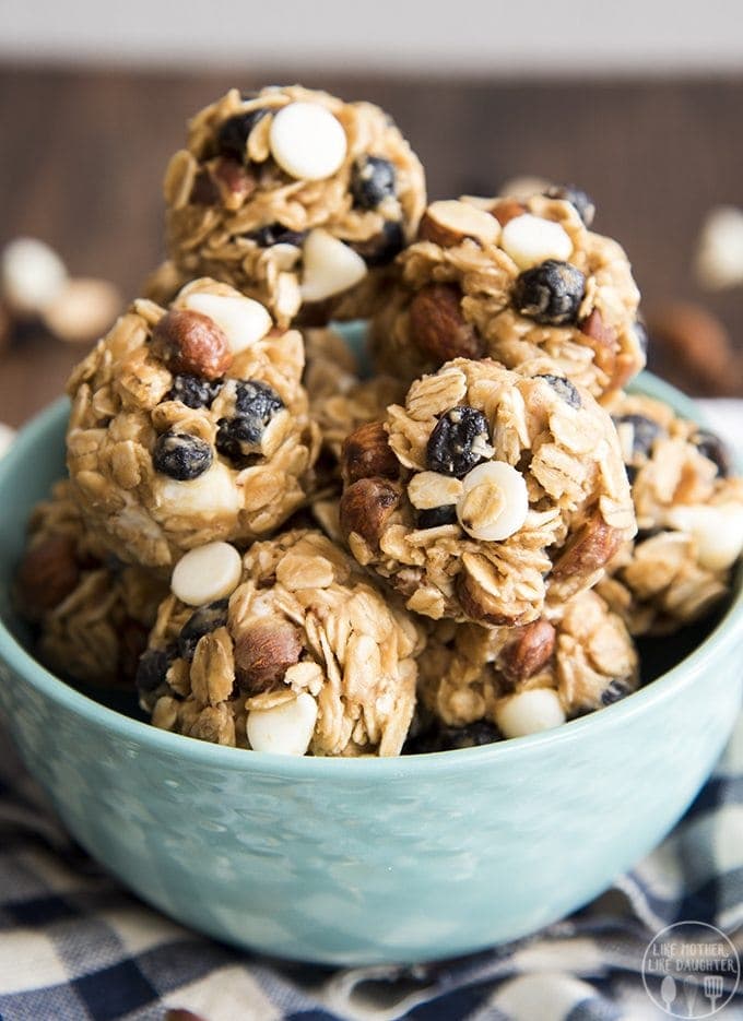 A bowl of granola energy balls full of white chocolate chips, blueberries, and almonds.