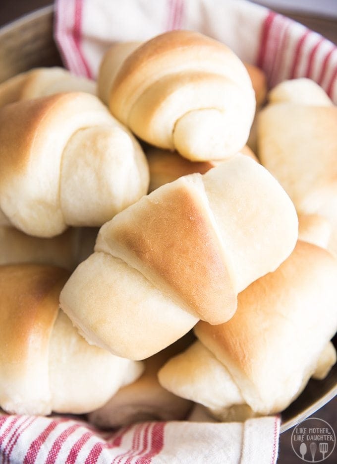 A close up of crescent roll style rolls in a bowl.