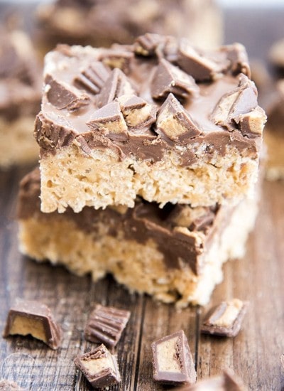 A stack of two peanut butter rice krispie treats topped with chocolate and peanut butter cups.