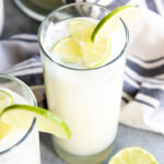 A creamy glass of Brazilian lemonade topped with lime slices.