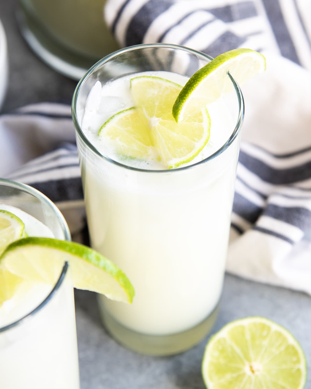 A creamy glass of Brazilian lemonade topped with lime slices.