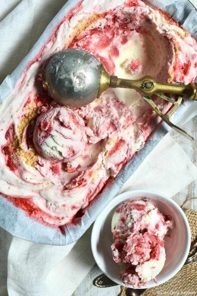 A container of strawberry shortcake ice cream with an ice cream scoop on it.