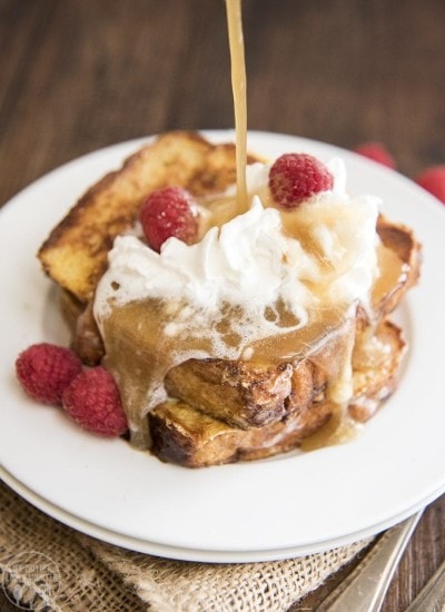 Caramel syrup being poured over a stack of French toast.
