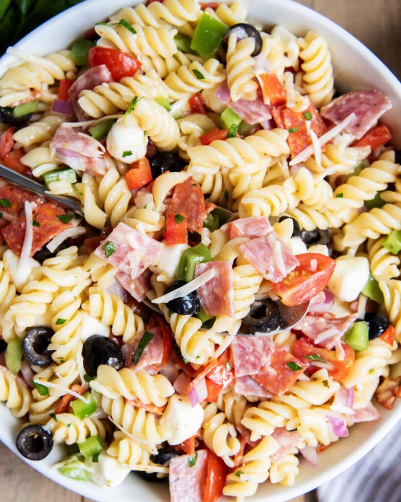 A close up of a bowl of Italian Pasta Salad with pepperoni and salami.