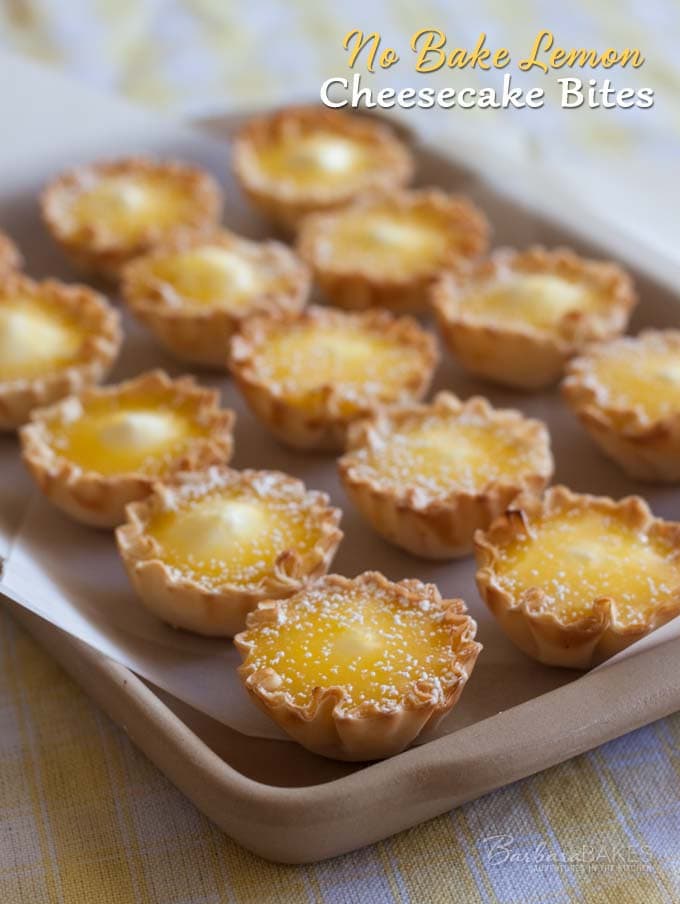 Small lemon cheesecake phyllo bites on a baking pan.