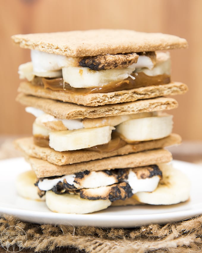A stack of caramel banana filled s\'mores on a plate. 