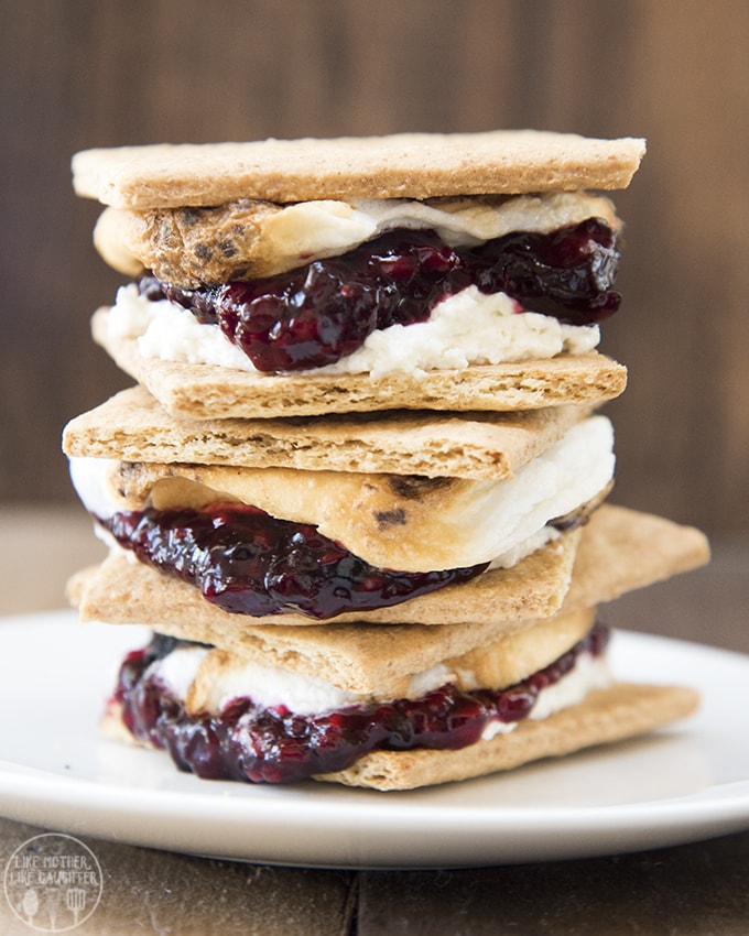 A stack of s\'mores made with graham cracker, marshmallow, jam, and whipped cream cheese.