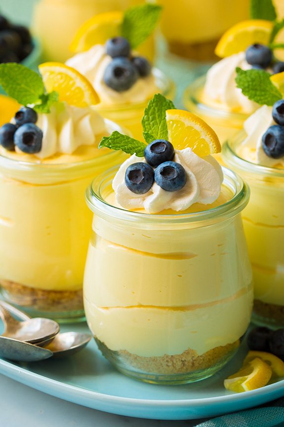 Lemon cheesecake mousse in glasses topped with whipped cream, and fresh blueberries. 