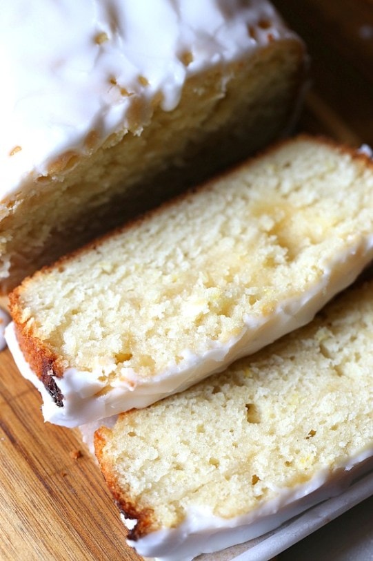 A slice of a lemon sweet bread topped with a white glaze. 