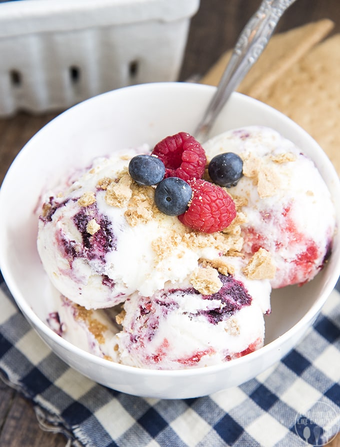 A white bowl full of scoops of berry swirled cheesecake ice cream. 
