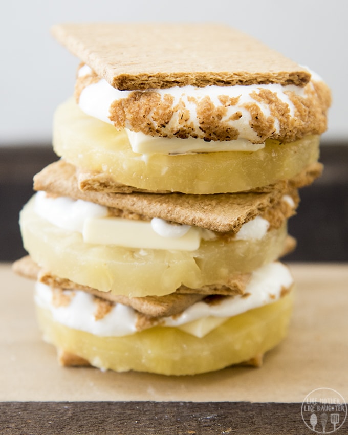 A stack of s\'mores with white chocolate and pineapple slices in them. 