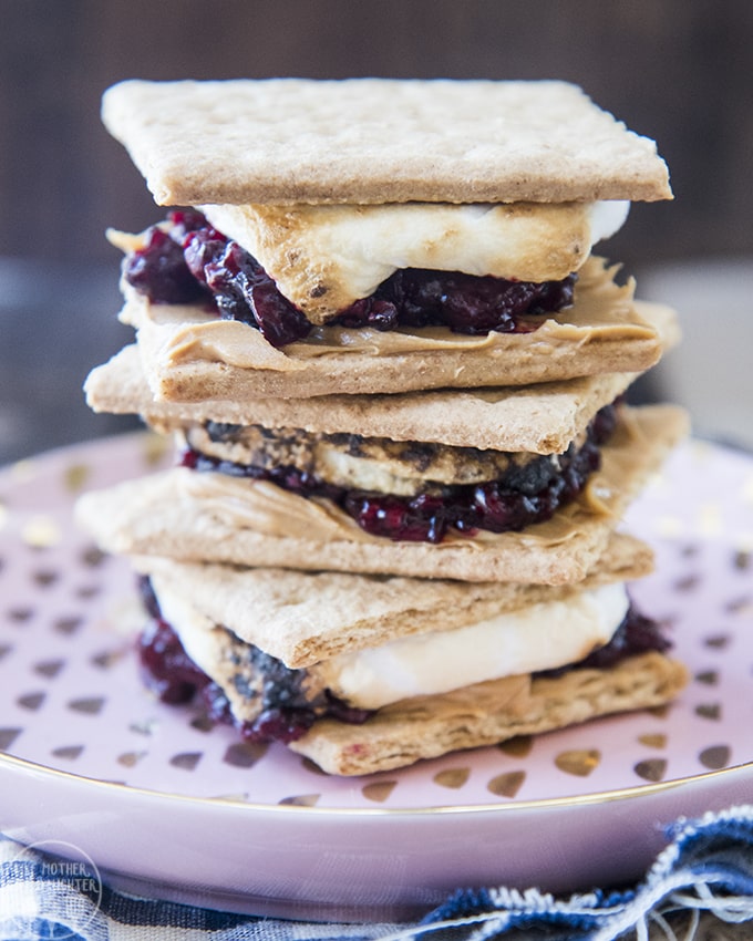 A stack of s\'mores made with peanut butter and jelly in them. 