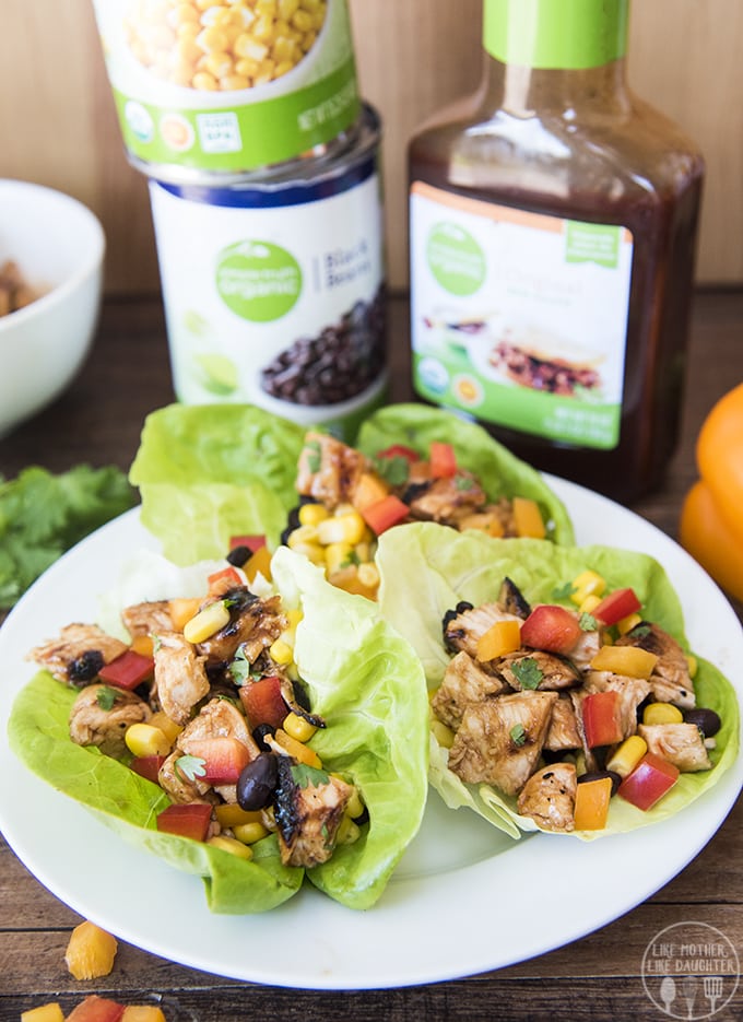 BBQ Chicken lettuce wraps with a bottle of barbecue sauce behind them. 