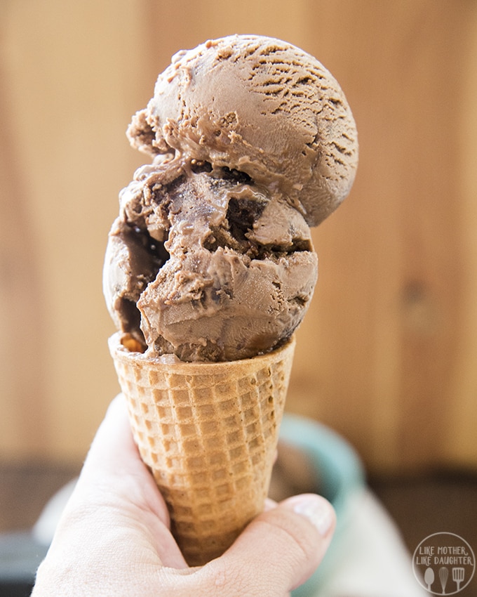 A hand holding an ice cream cone filled with chocolate brownie ice cream. 