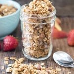 A glass jar filled with homemade coconut almond granola.