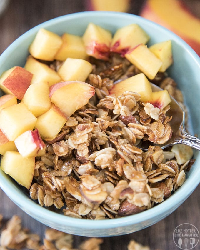 A bowl of granola and peaches. 