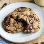 Three Nutella chocolate chip cookies on a plate, and one has a bite out of it.