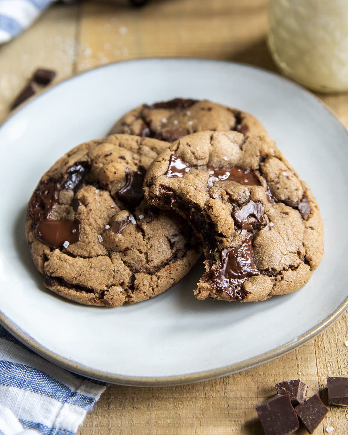 Three Nutella chocolate chip cookies on a plate, and one has a bite out of it.