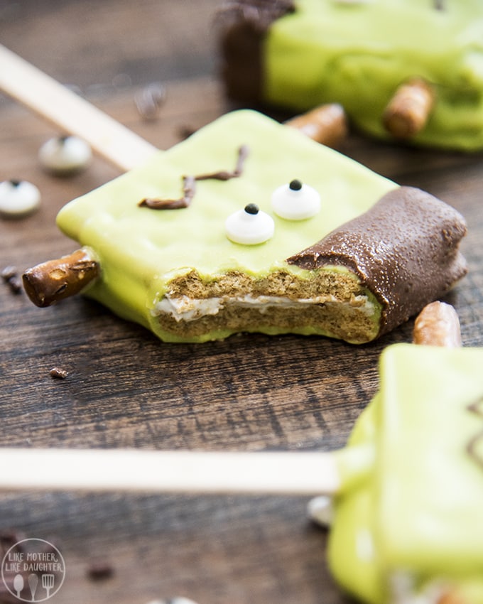 Frankenstein pops are smores on a stick made green and decorated to look like Frankenstein's monster and are perfect for Halloween