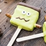A smores pop decorated with green candy melts and eye balls to look like frankensteins monster.