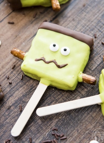 A smores pop decorated with green candy melts and eye balls to look like frankensteins monster.