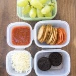 A homemade pizza lunchable, with each part in small plastic containers.