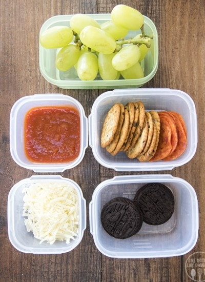 A homemade pizza lunchable, with each part in small plastic containers.