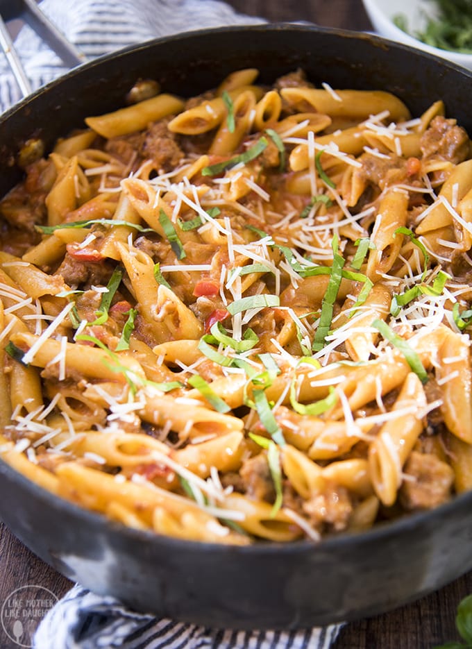 A pan of one pot sausage pasta made with penne and topped with fresh basil. 