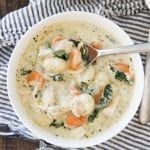 A bowl of creamy chicken gnocchi soup with carrots and spinach.