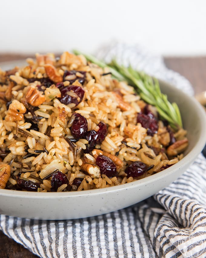 A bowl of wild rice mixed with cranberries and pecans. 