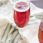 A glass of a red sparkly pomegranate drink.
