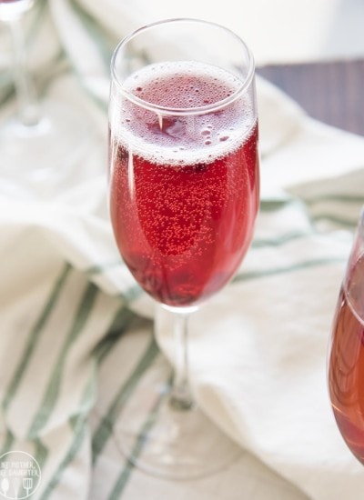A glass of a red sparkly pomegranate drink.