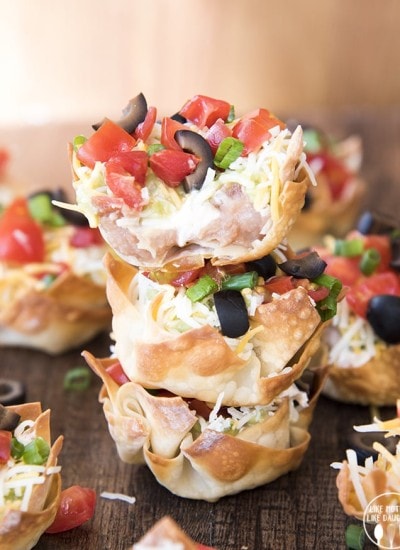 A stack of three 7 layer dip wonton cups.