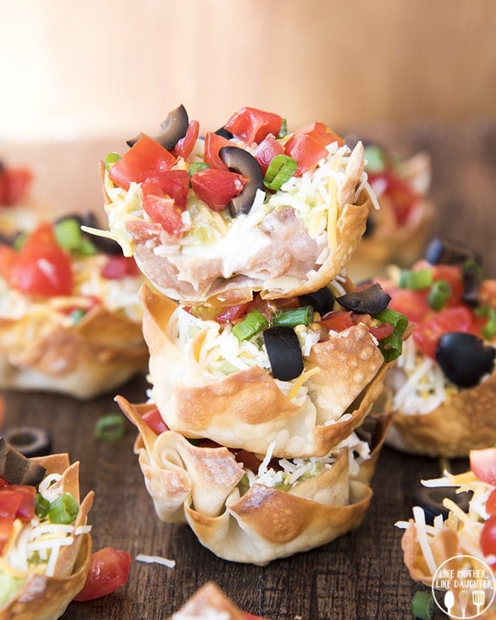A stack of three 7 layer dip wonton cups.