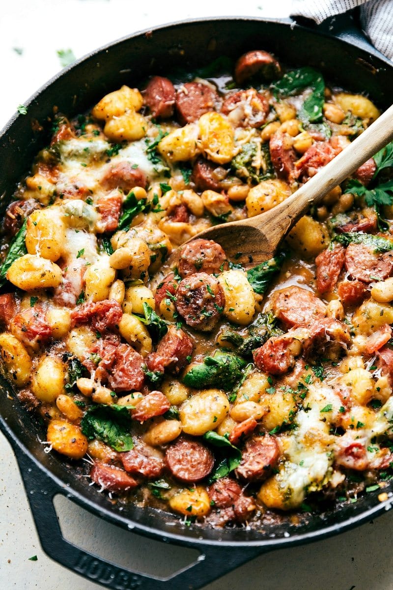 A pan filled with gnocchi, sausage, and vegetables.