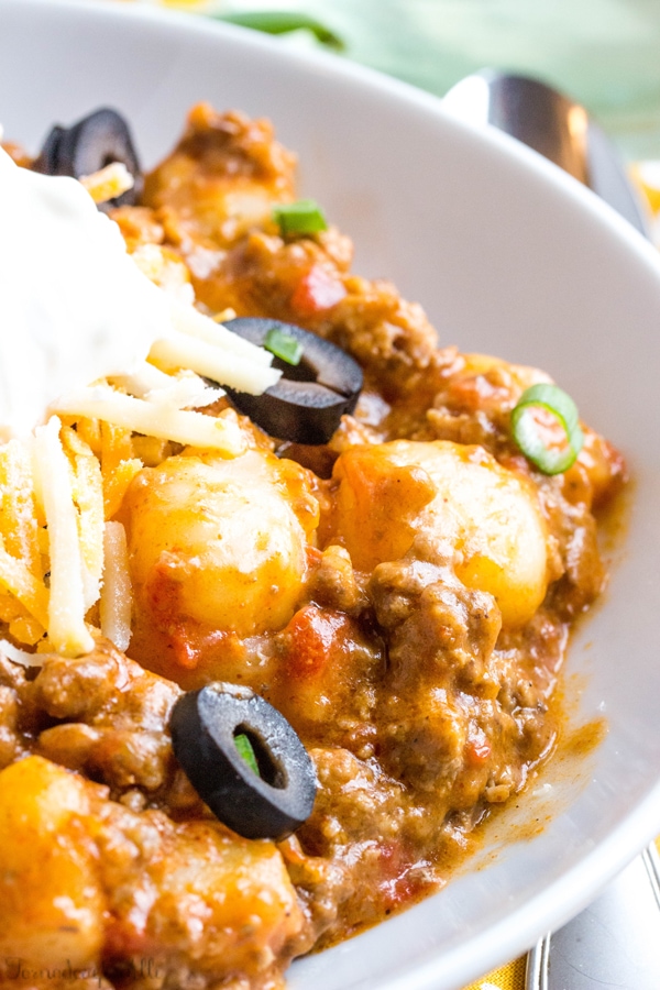 A bowl of one pot taco gnocchi topped with olives. 