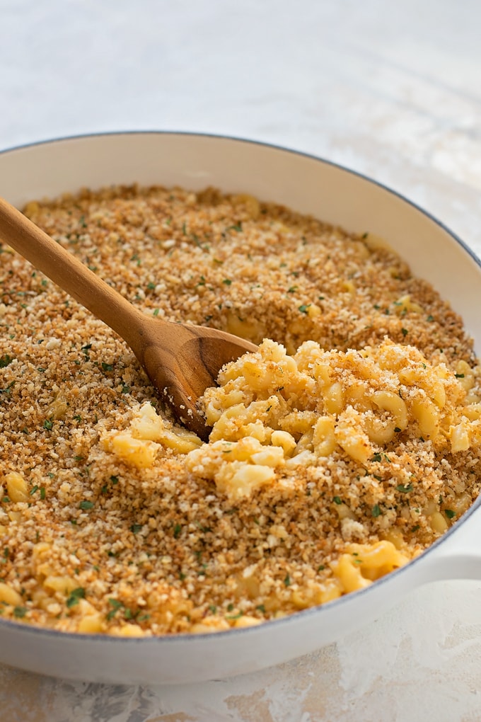 A skillet full of mac and cheese topped with bread crumbs. 