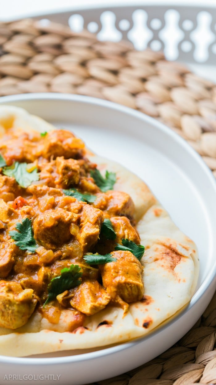 A plate of chicken tikka masala on a pita. 