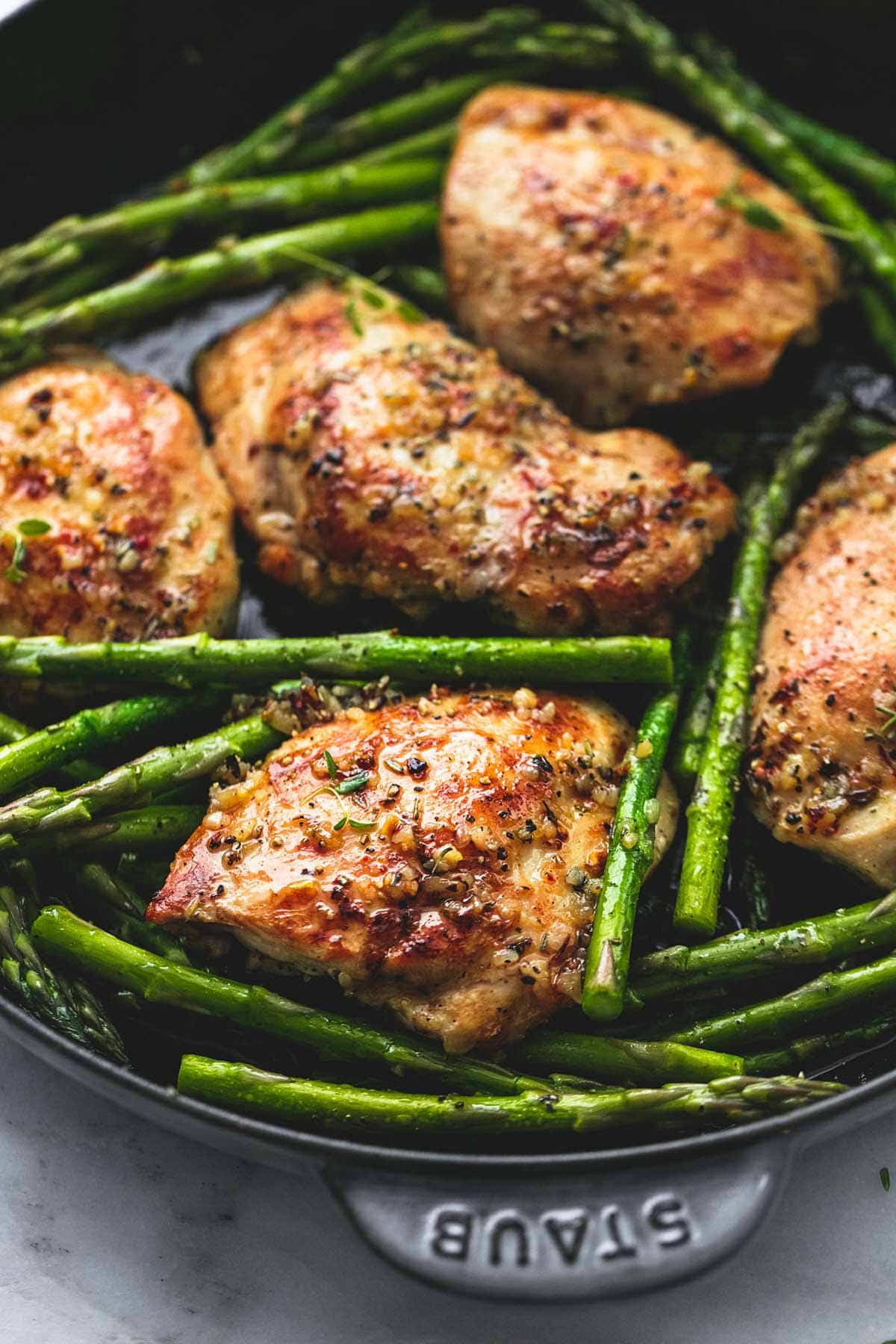 Garlic herb chicken and asparagus in a skillet. 