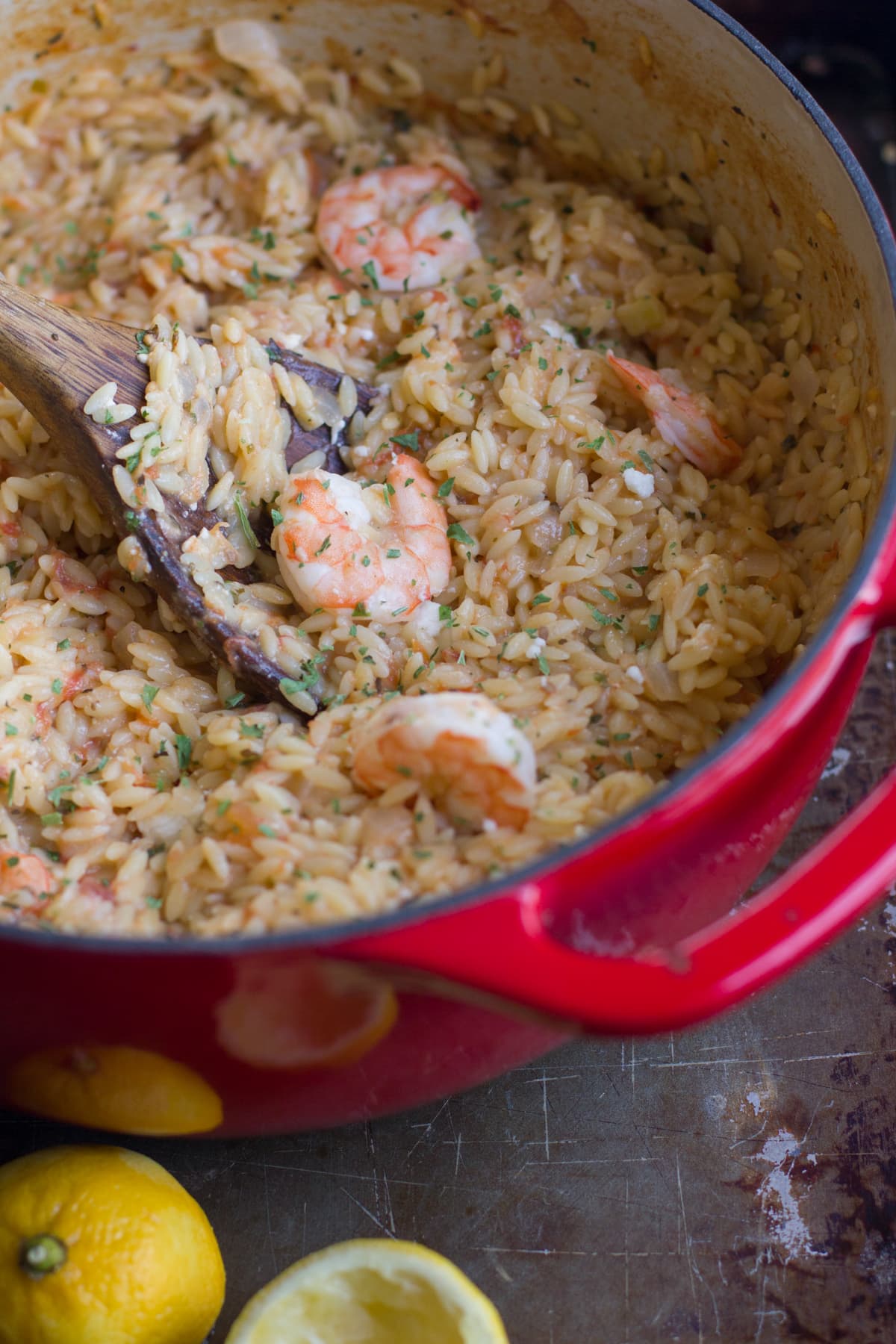 A dutch oven full of an orzo mixture with shrimp. 