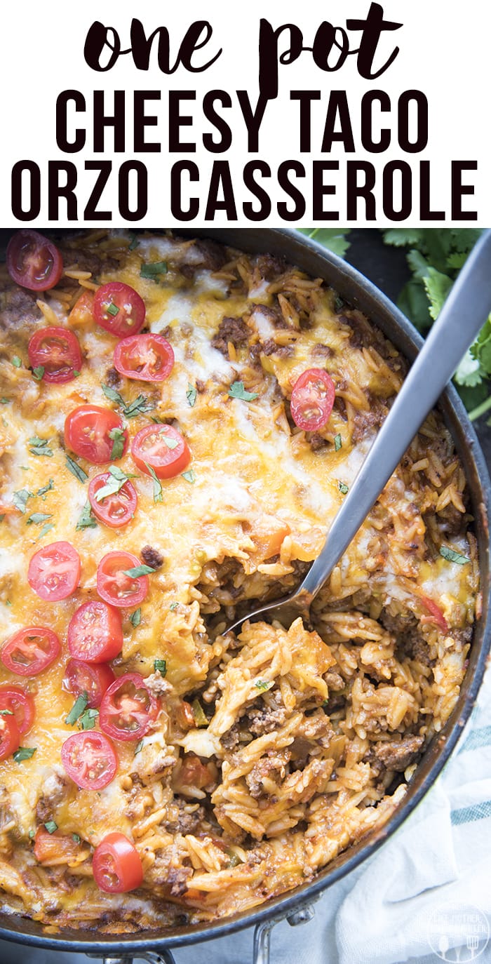 A pan of one pot taco pasta topped with cilantro and sliced cherry tomatoes.