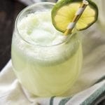 A glass of lime sherbet punch topped with a lime slice.