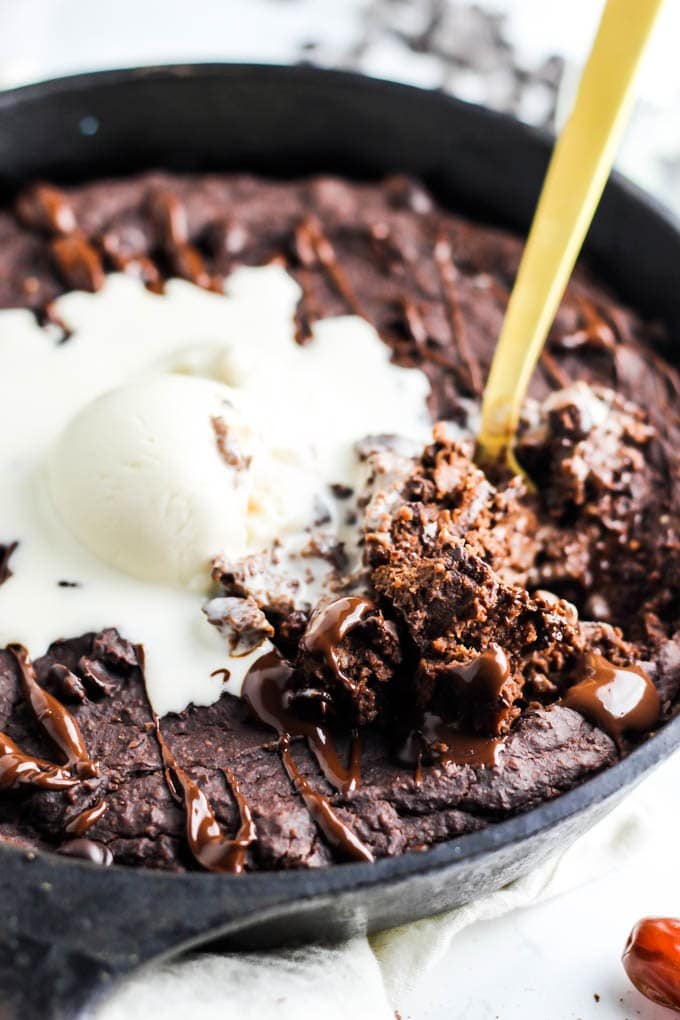 A chocolate lentil brownie topped with a scoop of vegan ice cream. 
