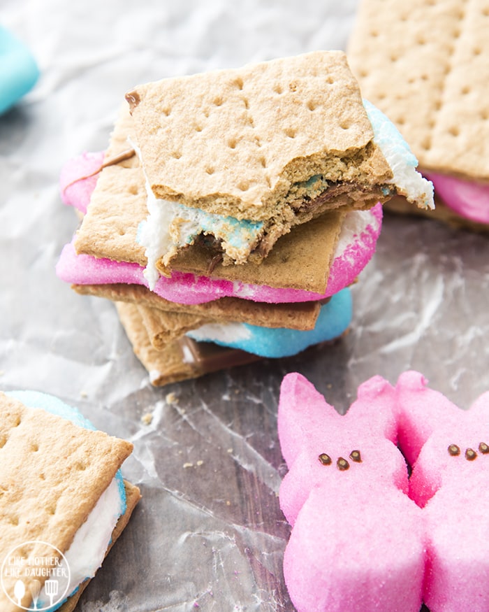 Peep smores in a stack, with the top one having some bites taken out of it.