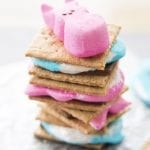 A stack of smores made with blue and pink peeps with a bunny peep on top.
