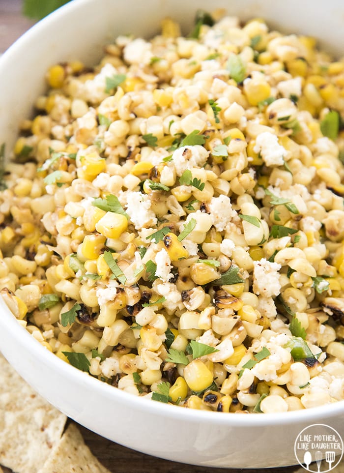 A bowl of Mexican street corn dip with cotija and cilantro.