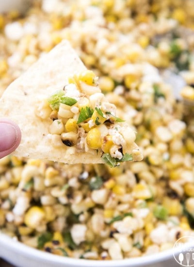 A chip topped with Mexican street corn dip.